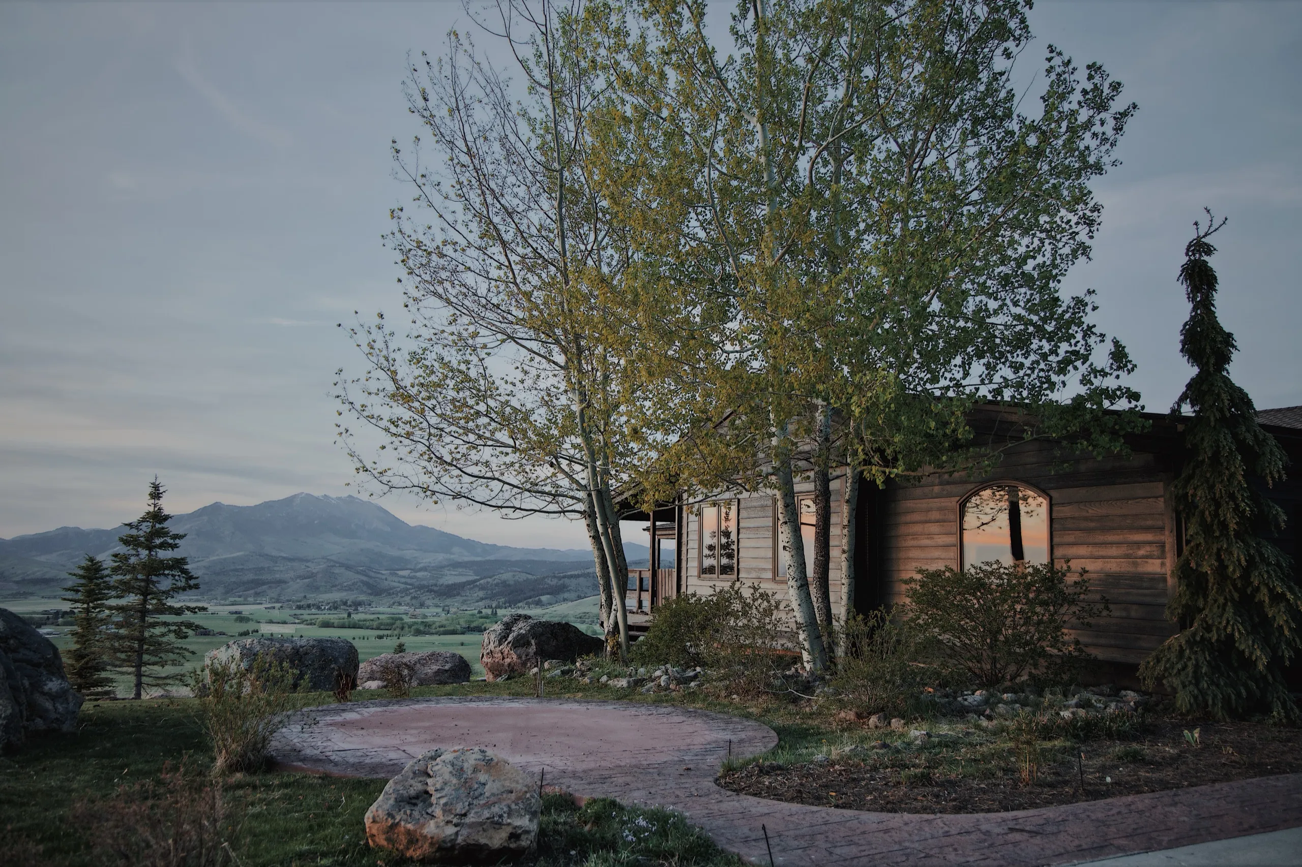 The lodge exterior from below the hill, wraparound deck at dusk