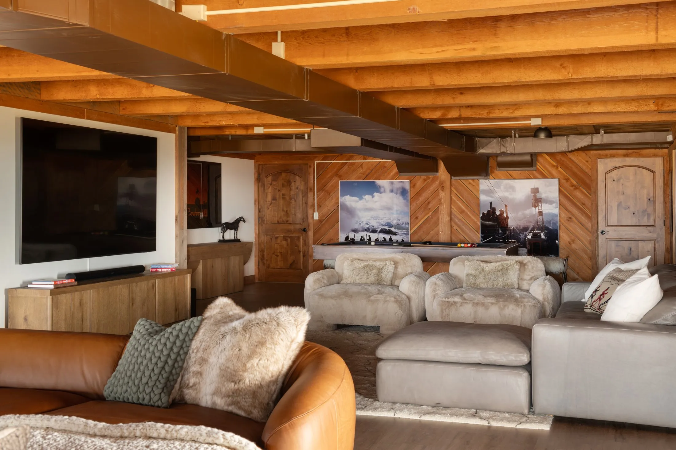 Media room with sectional, cozy chairs and 98-inch TV - lower level